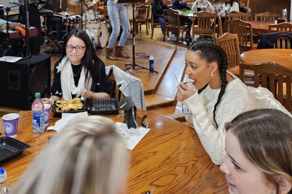 Students talk and eat in MacKenzie's as a band plays in the background